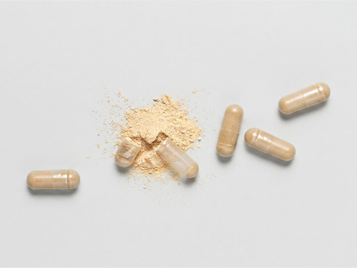 Opened medical capsules showing beige powder when viewed from above.